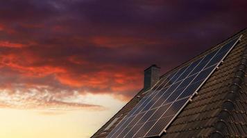 Solar panels producing clean energy on a roof of a residential house during sunset. photo