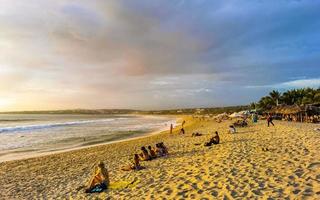 Puerto Escondido Mexico Oaxaca Mexican 2022 Colorful golden sunset people wave and beach Puerto Escondido Mexico. photo