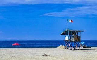 Puerto Escondido Mexico Oaxaca Mexican 2022 Sunshine parasol waves and beach sand Puerto Escondido Mexico. photo