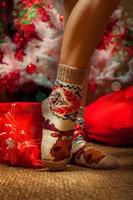 female legs in funny socks with a lot of christmas gifts photo