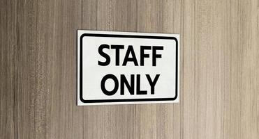 Warning silver stainless steel sign with character black message staff only in front of the wooden door photo