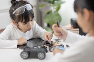 Two Asian students learn coding robot cars and electronic board cables in STEM, STEAM, mathematics engineering science technology computer code in robotics for kids concepts. photo