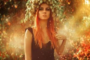 Serious young adult lady with hop on head in magic forest outdoors photo