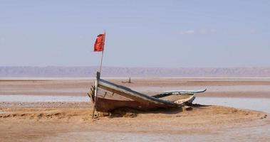 Salt lake in Tunisia Chott el Djerid during a sunny windy day. Largest salt lake in the Sahara Desert. Tourist destination. Travel the world. Boat on the dry lake. Mysterious landscape. video