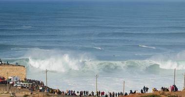 nazare, portugal - 7 novembre 2022 les gens regardent les grandes vagues géantes s'écraser à nazare, portugal. plus grosses vagues du monde. destination touristique pour le surf. video