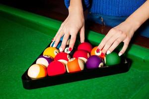 female hands are arranged billiard balls in triangle photo