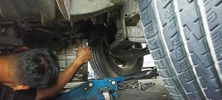 tren de aterrizaje del coche y mecánico reparando el tren de aterrizaje del coche foto