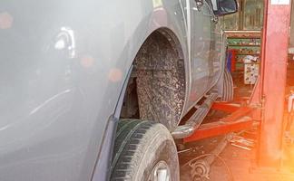 Side view of a car lifted off the ground by a large jack. photo