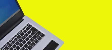 top right view of white laptop on yellow background photo