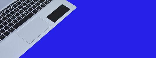 front view of white laptop on blue background photo