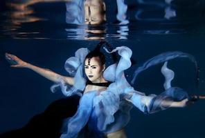 bella joven artística bailando bajo el agua. sirena, danza, concepto de hadas foto