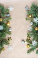 border of fir tree branch with gold decoration on craft paper for christmas card with copy space for text. photo