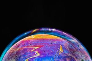 Virtual reality space with abstract multicolor psychedelic planet. Closeup Soap bubble like an alien planet on black background. photo