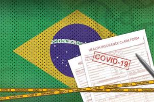 Brazil flag and Health insurance claim form with covid-19 stamp. Coronavirus or 2019-nCov virus concept photo