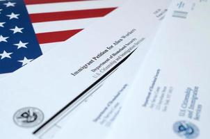 El formulario en blanco de la petición de inmigrantes i-140 para trabajadores extranjeros se encuentra en la bandera de los Estados Unidos con un sobre del departamento de seguridad nacional foto