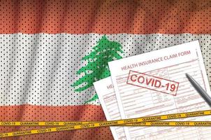 formulario de reclamo de seguro de salud y bandera de líbano con sello covid-19. coronavirus o concepto de virus 2019-ncov foto