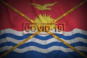 Kiribati flag and Covid-19 stamp with orange quarantine border tape cross. Coronavirus or 2019-nCov virus concept photo