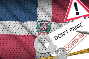 Dominican Republic flag and police handcuffs with inscription Don't panic on white paper. Coronavirus or 2019-nCov virus concept photo