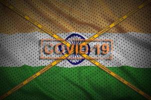 India flag and Covid-19 stamp with orange quarantine border tape cross. Coronavirus or 2019-nCov virus concept photo