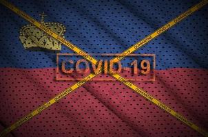 Liechtenstein flag and Covid-19 stamp with orange quarantine border tape cross. Coronavirus or 2019-nCov virus concept photo