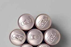 muchas latas de aluminio nuevas de refrescos o envases de bebidas energéticas. concepto de fabricación de bebidas y producción en masa foto