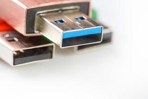 Detailed view of a black USB flash drive with a silver-blue connector. Photo on a white background