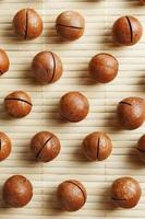 Macadamia nuts are made up of patterns on a bamboo light background. Patterns, repeats, texture and background photo