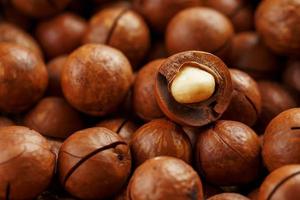 nueces de macadamia en grandes cantidades a granel en forma de textura de fruta natural fresca sin cáscara una nuez en la vista de primer plano del marco foto