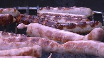 HD close up video of sausage being cooked on a barbecue. Cooked and sizzling