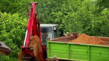 excavator loads the ground in the truck video