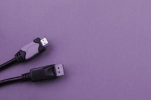 Audio video HDMI computer cable plug and 20-pin male DisplayPort gold plated connector for a flawless connection on purple backdrop photo