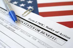 El formulario en blanco del aviso de acción i-797c se encuentra en la bandera de los Estados Unidos con un bolígrafo azul del departamento de seguridad nacional foto