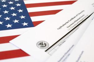 la solicitud n-600 para el certificado de ciudadanía en blanco se encuentra en la bandera de los estados unidos con un sobre del departamento de seguridad nacional foto