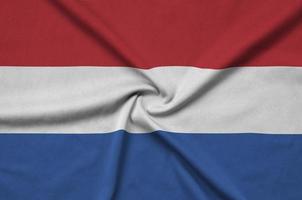 Netherlands flag  is depicted on a sports cloth fabric with many folds. Sport team banner photo