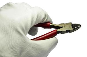 Hand holding the red cutting pliers photo