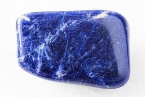 tumbled Sodalite rock on white marble photo