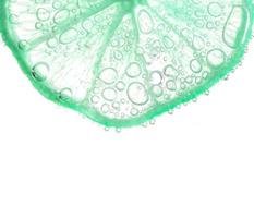 jugosas rodajas de lima con burbujas bajo el agua aisladas en fondo blanco. fondo de textura de patrón de rodajas de limón verde. foto