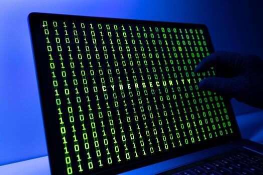 Ciber security concept. Gloved Hand, Binary code and cybersecurity word on laptop computer screen photo