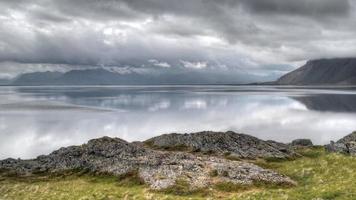 HD video of timelapse clouds at over a mountain range and fjord in Iceland. HDR, HD timelapse video