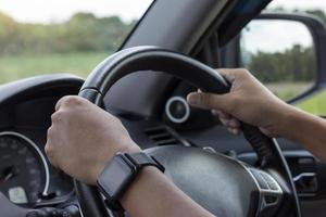 Hand of man driving inside car and blur nature background. photo