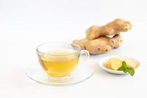 A cup of tea with ginger root on white background. Health drink concept. photo