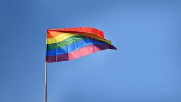 'feliz mes del orgullo' en el fondo de las banderas del cielo azul y el arco iris, concepto para las celebraciones lgbtqai en el mes del orgullo, junio de 2023. foto