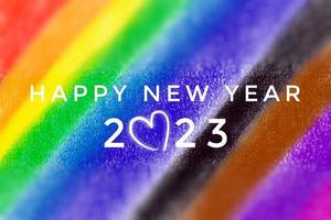 HAPPY NEW YEAR 2023 on blurred hand drawing rainbow colors background, concept for greeting invitation card and happy new year 2023 concept. photo