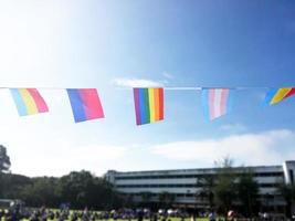 Rainbow flags and lgbtq plus flags were hung on wire against bluesky on sunny day, soft and selective focus, concept for LGBTQ plus gender celebrations in pride month around the world. photo