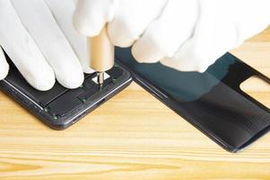 Image of a technician screwing the back of a mobile phone photo