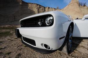Headlights of white powerfull american muscle car in career. photo