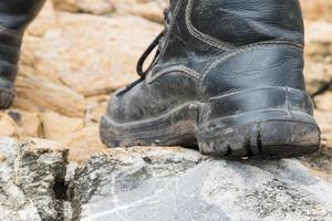 bota de cuero trekking en la roca foto