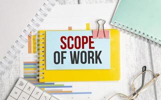 Scope Of Work words on blue sticker . Conceptual background with chart ,papers and pen photo