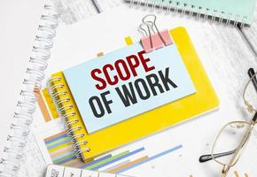 Scope Of Work words on blue sticker . Conceptual background with chart ,papers and pen photo