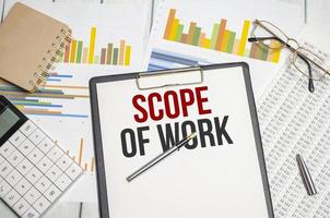 Scope Of Work words on paper tablet. Conceptual background with chart ,papers and pen photo